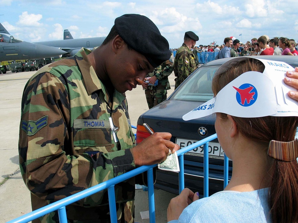 Airman Shares American Currency with Russian Girl at Moscow Air Show