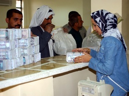Bank Worker Exchanges Old Iraqi Currency for New Dinars in Mosul