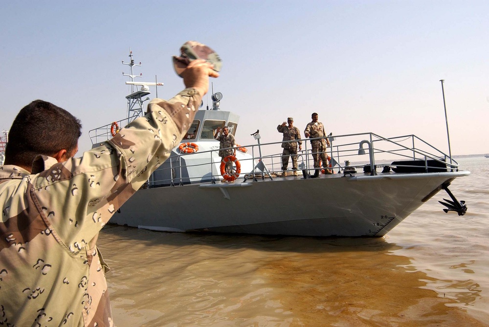 Servicemember Waves Farewell as Fast Boat Departs Umm Qasr Port
