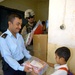 Iraqi Police Officer Distributes School Supplies to Students with U.S. Army Support