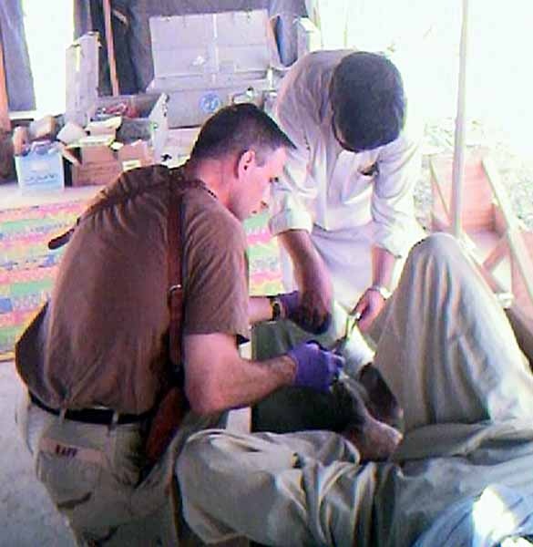 Navy Doctor Examines Patient with Afghan Counterpart at Clinic in Afghanistan