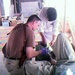 Navy Doctor Examines Patient with Afghan Counterpart at Clinic in Afghanistan