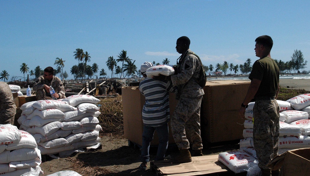 U.S. Sailor Assists Indonesian Resident with Disaster Relief Supplies