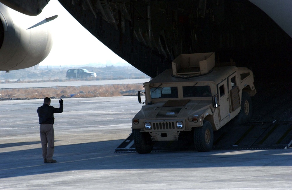 Airman Guides Humvee Off C-17 at Bagram Airfield