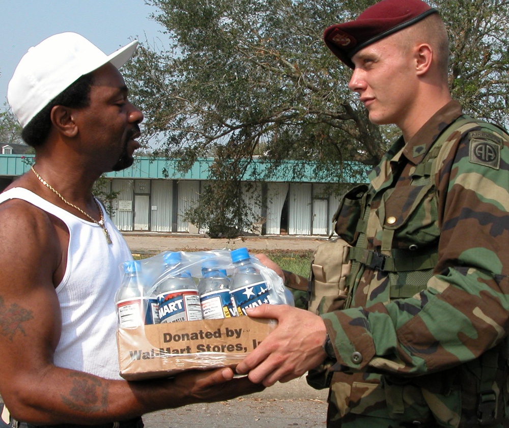Algiers Resident Receives Water Aid from Army Paratrooper