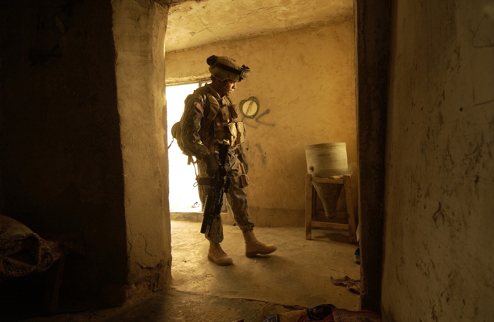 Soldier Searches for Weapons Caches in Iraq