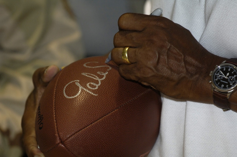 Pro Football Hall of Famer Gale Sayers Signs Football for Servicemember During USO Tour in Kuwait