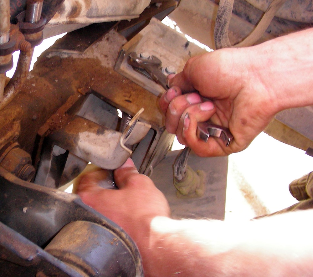 Mechanic Tightens Bolt on Humvee in Iraq