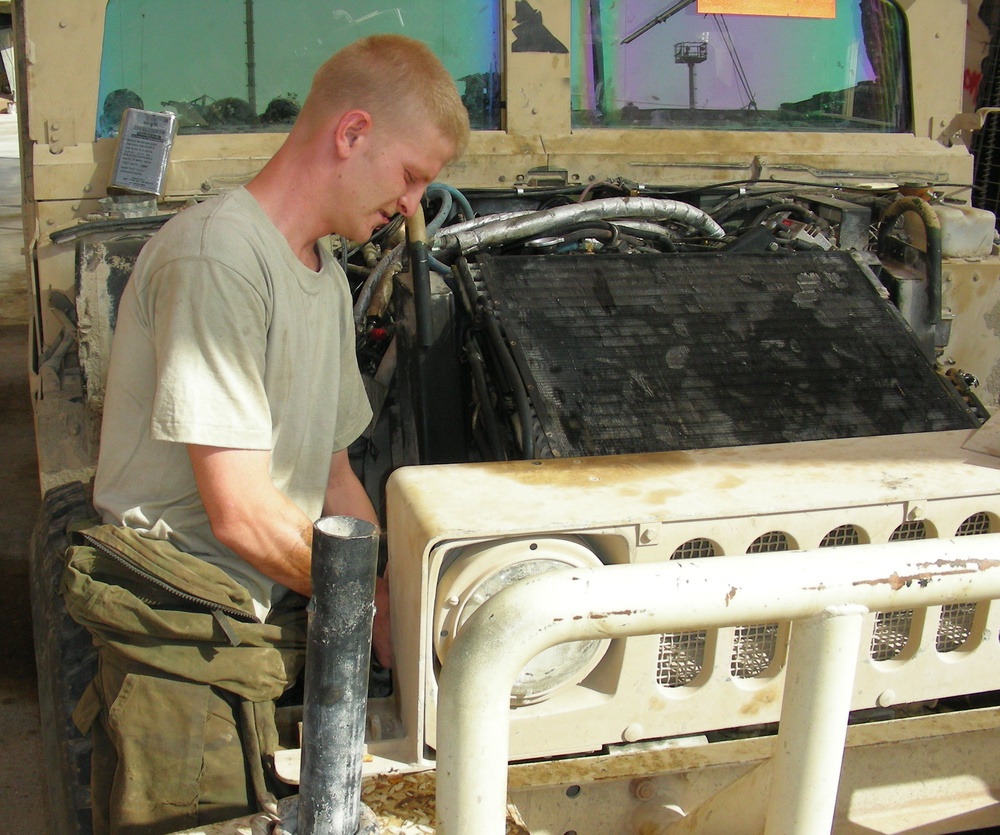 Soldier Maintains Humvee in Iraq