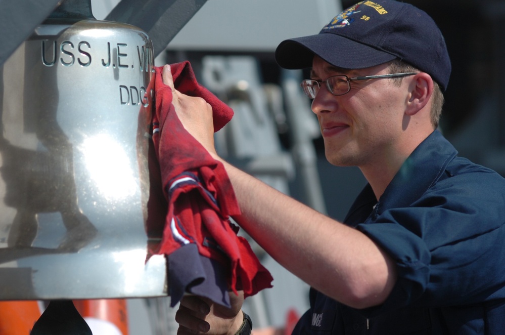 Crewmember Polishes Ship's Bell Aboard USS James E. Williams