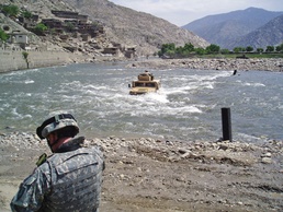 Marines Cross Pech River in Armored Vehicles as Soldier Observes