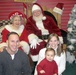 Family Poses for Holiday Portrait with Santa and Mrs. Claus in North Pole, Alaska