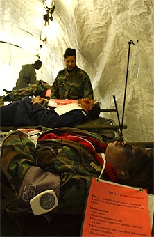 Air Force Chief Master Sgt. Checks on Simulated Burn Patients During Exercise