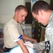 Army Medic Administers IV to Soldier at Forward Operating Base in Iraq