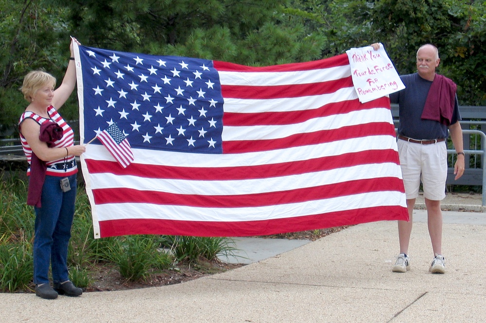 Bryson Family Honors 9/11 Cyclists with Flag and Sign