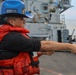 STG3 Iyan Rosales heaves on a phone and distance line during a COMPTUEX replenishment-at-sea