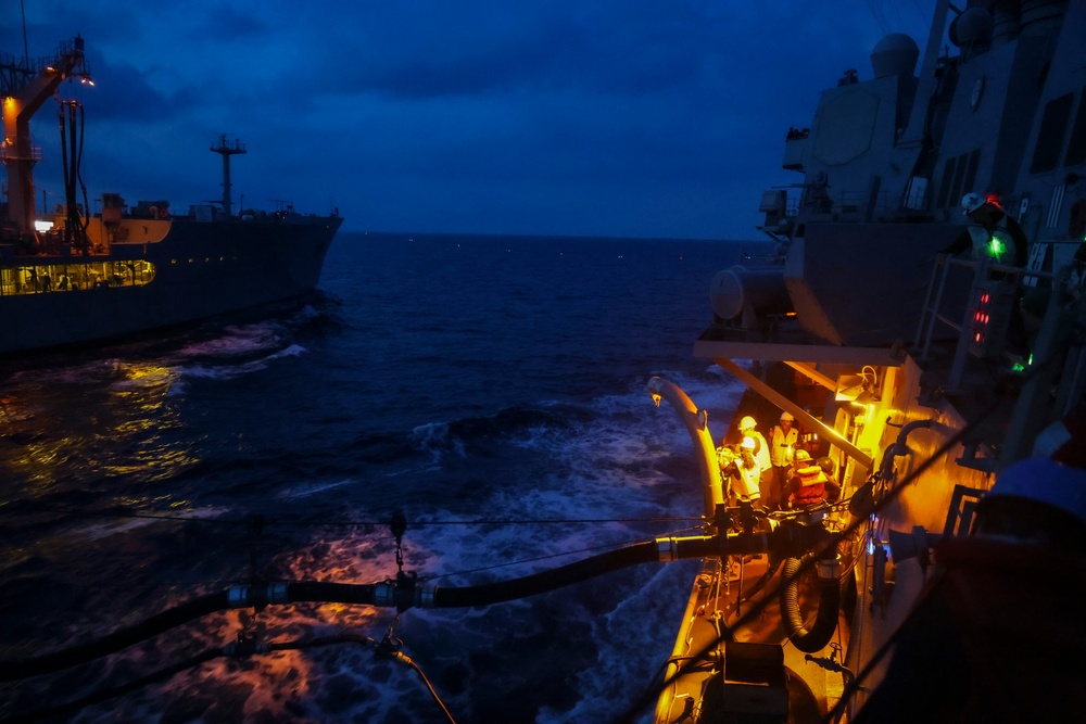 U.S. Navy Sailors conduct a night time replenishment-at-sea during COMPTUEX