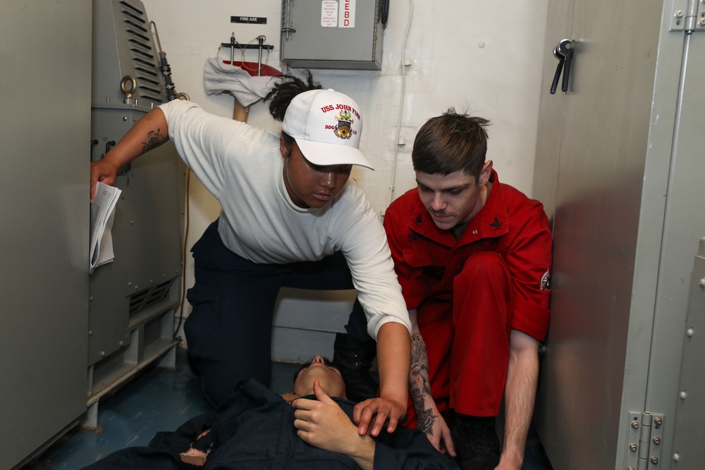 Sailors aboard the USS John Finn conduct a medical training team drill in the Philippine Sea