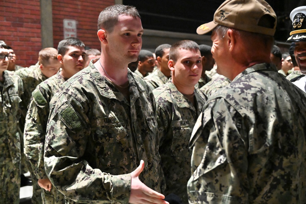 Navy Father hands son Navy ball cap following completion of Battle Stations.