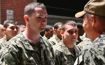 Navy Father hands son Navy ball cap following completion of Battle Stations.