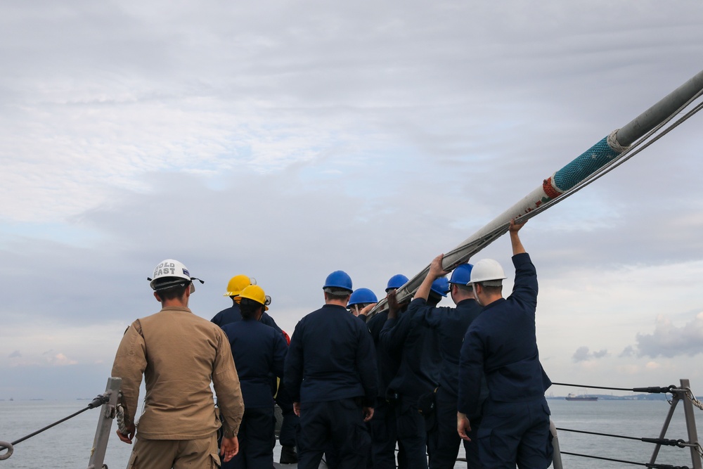 Sailors aboard the USS John Finn conduct a sea and anchor detail in Changi, Singapore