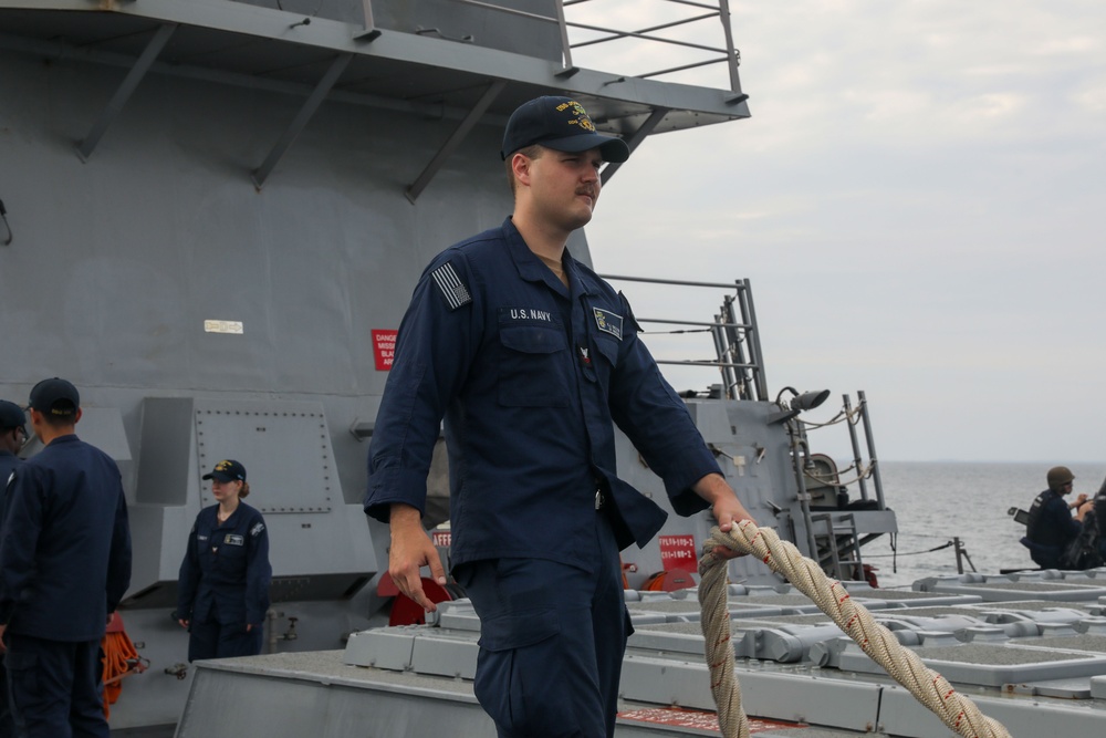 Sailors aboard the USS John Finn conduct a sea and anchor detail in Changi, Singapore