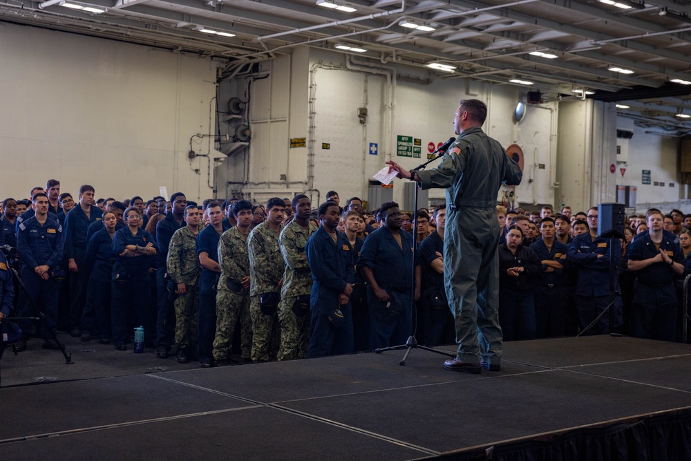 Abraham Lincoln conducts an all-hands call in the hangar bay