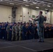 Abraham Lincoln conducts an all-hands call in the hangar bay