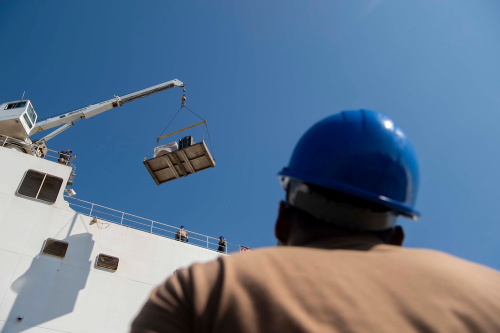 Sailors load medical supplies onto USNS Comfort