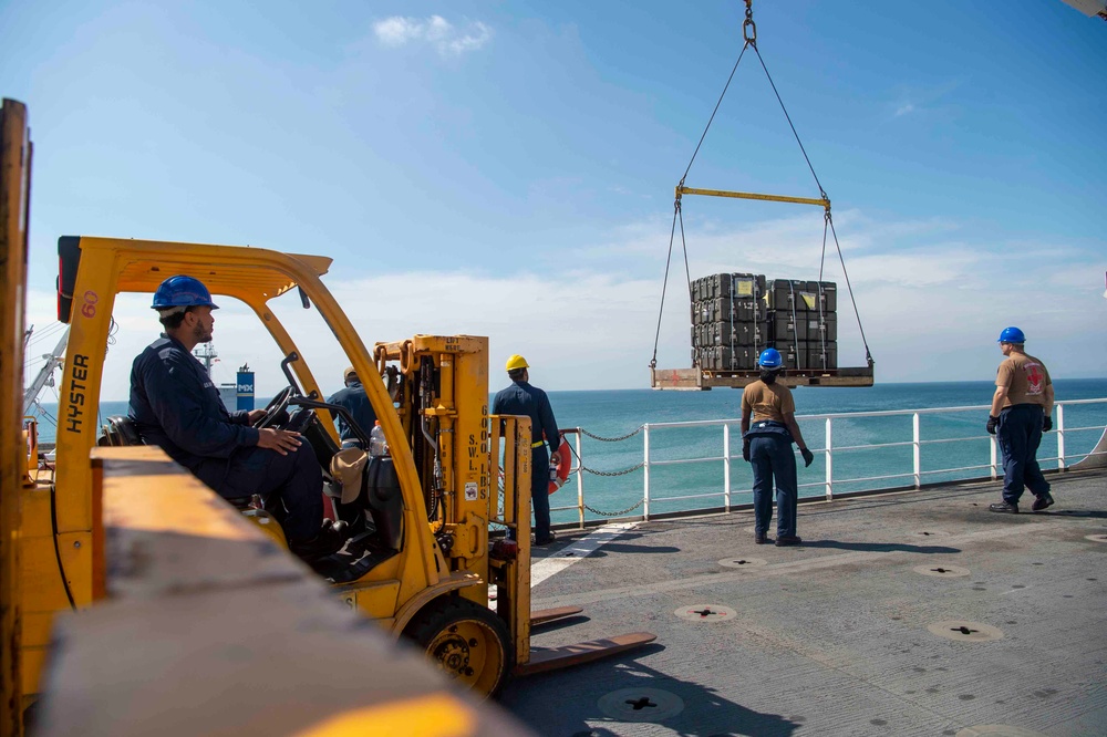 Sailors load medical supplies onto USNS Comfort