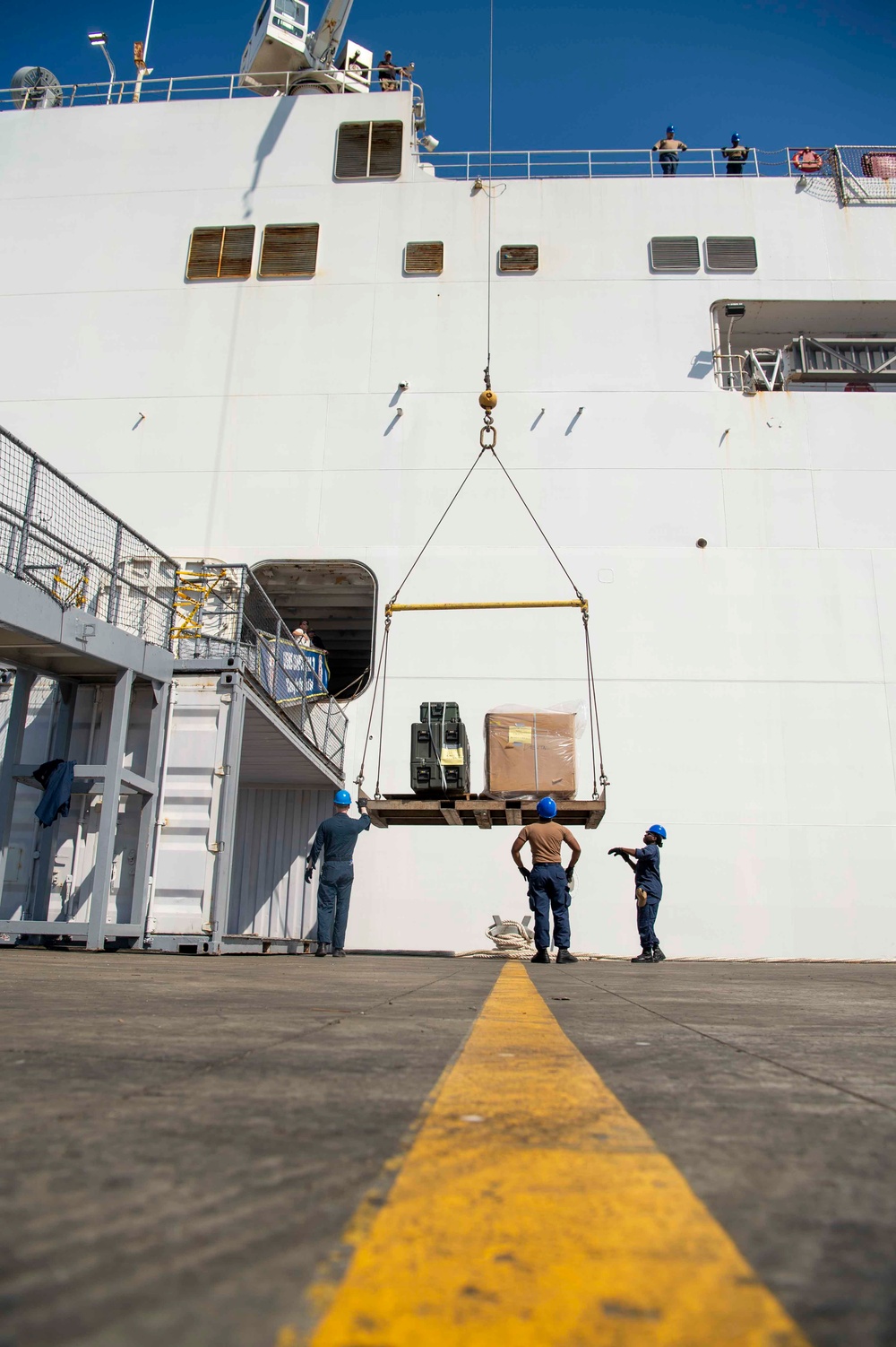 Sailors load medical supplies onto USNS Comfort