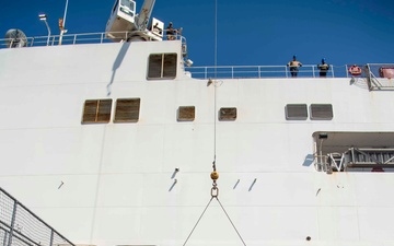 Sailors load medical supplies onto USNS Comfort
