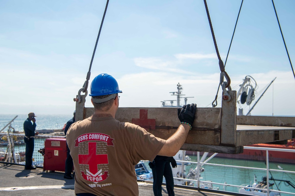 Sailors load medical supplies onto USNS Comfort