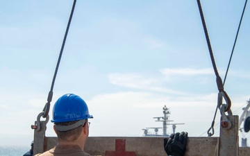 Sailors load medical supplies onto USNS Comfort