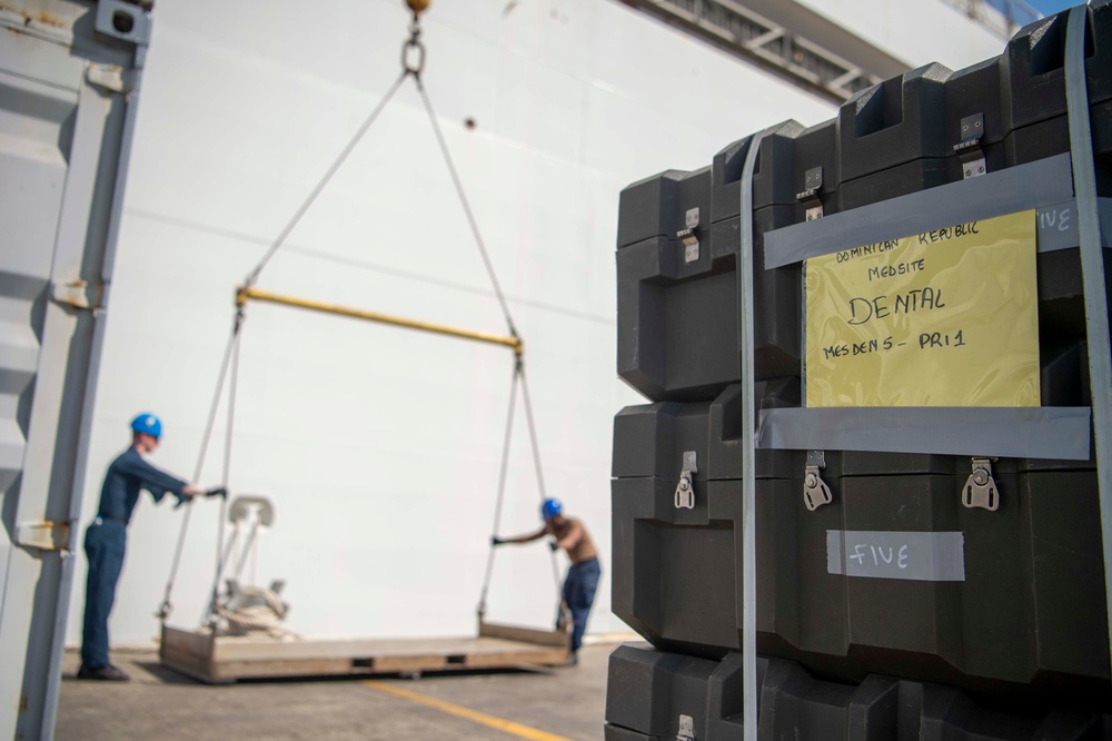 Sailors load medical supplies onto USNS Comfort