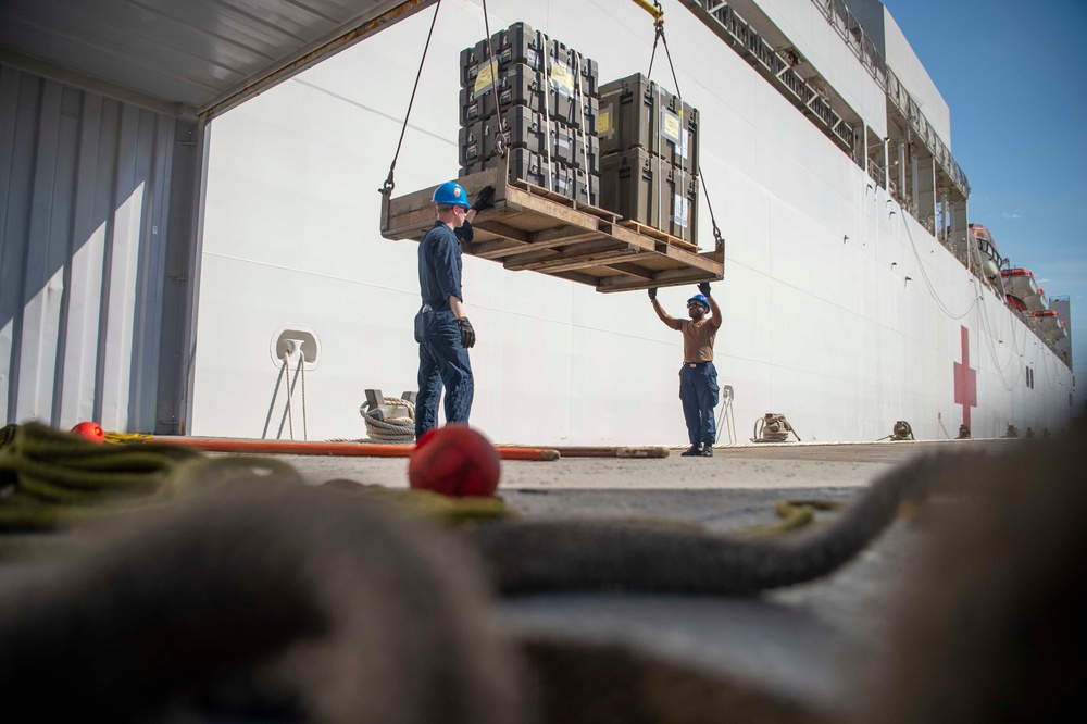 Sailors load medical supplies onto USNS Comfort