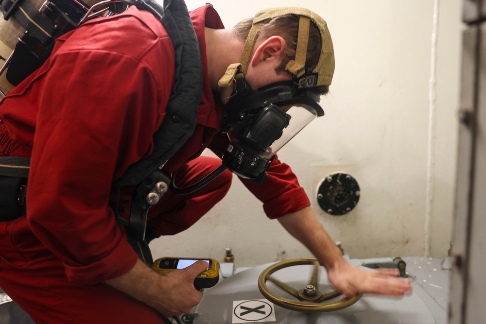 DC3 Levi Nuslein opens a water tight scuttle in response to a simulated toxic gas leak