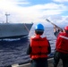 GMSN Cesar Juarez and GM3 Daniel Kininmonth shoot a heaving line with a M14 rifle during a replenishment-at-sea