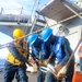 BM2 Kanim Hannigan, BMSN William Mwiseneza and BM3 Carlens Milice connect the surf hook to the tensioning line
