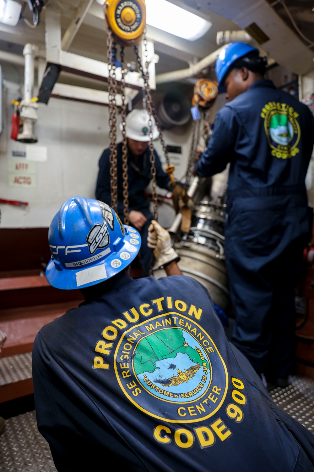 Sailors hoist an Allison gas turbine generator into the auxiliary engine room