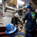Sailors hoist an Allison gas turbine generator into the auxiliary engine room