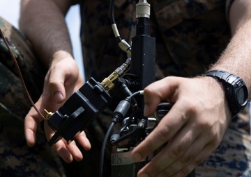 5th Air Naval Gunfire Liaison Company Marines craft expedient antennas with household goods