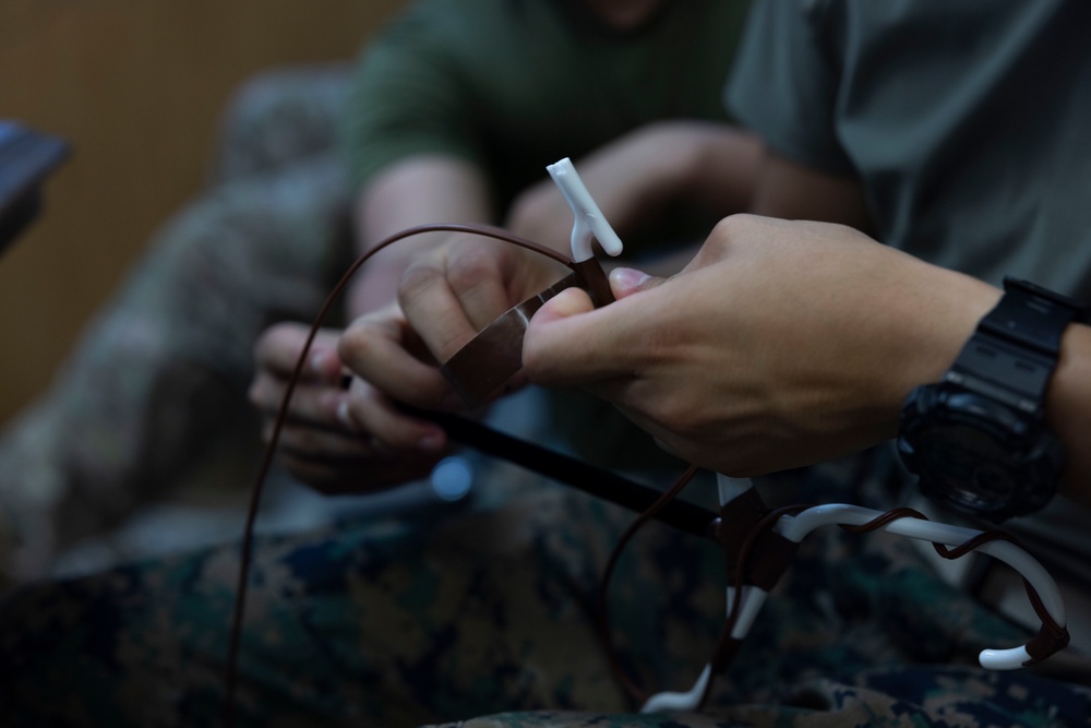 5th Air Naval Gunfire Liaison Company Marines craft expedient antennas with household goods
