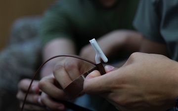 5th Air Naval Gunfire Liaison Company Marines craft expedient antennas with household goods