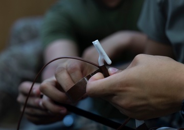 5th Air Naval Gunfire Liaison Company Marines craft expedient antennas with household goods