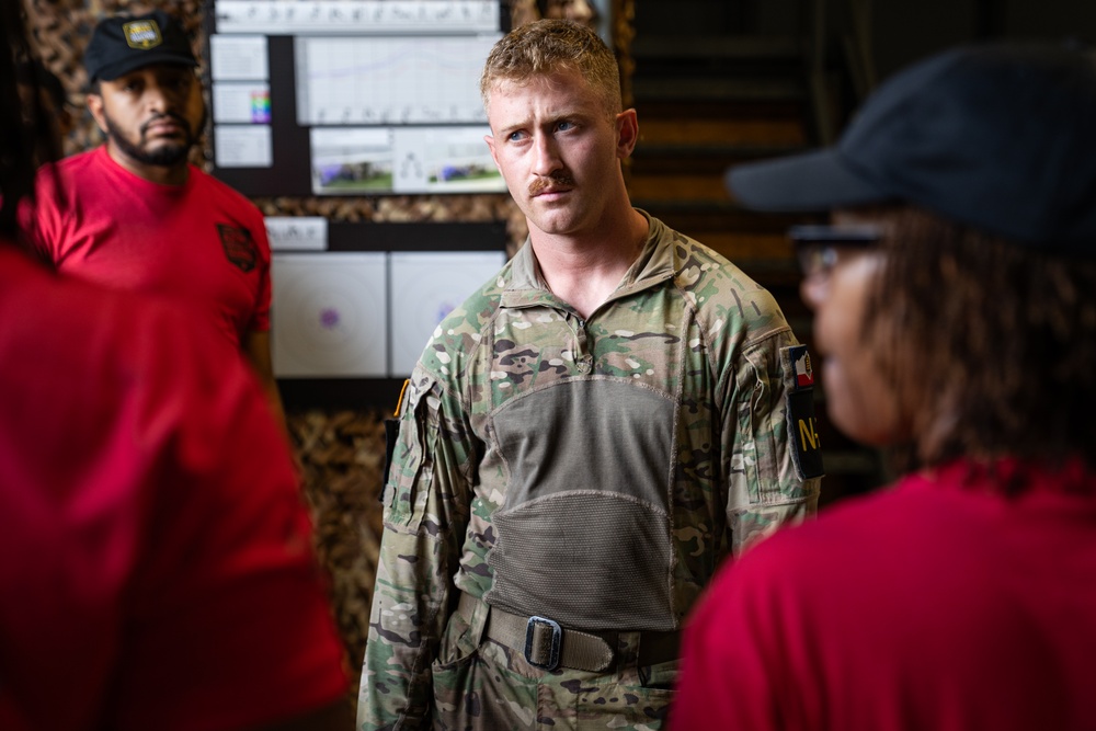 Sgt. Luke Cloward receives  brief on indoor obstacle course-2025 National Best Warrior