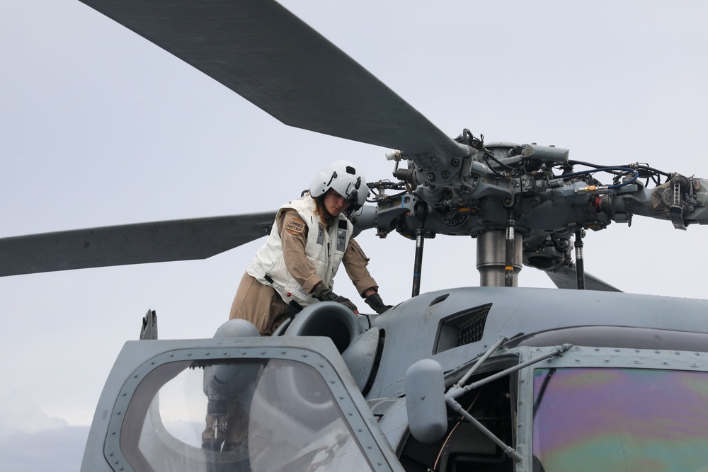 Sailors aboard the USS John Finn conduct routine maintenance on an MH-60R Sea Hawk in the Strait of Malacca