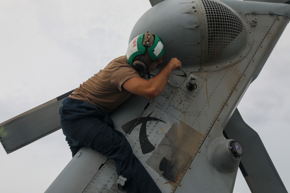 Sailors aboard the USS John Finn conduct routine maintenance on an MH-60R Sea Hawk in the Strait of Malacca
