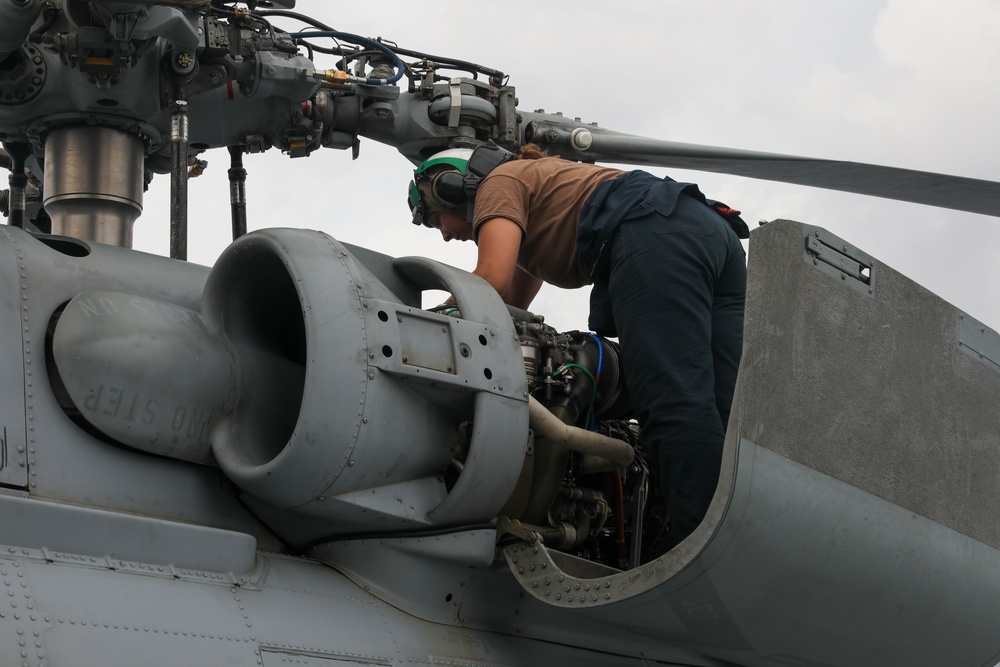 Sailors aboard the USS John Finn conduct routine maintenance on an MH-60R Sea Hawk in the Strait of Malacca