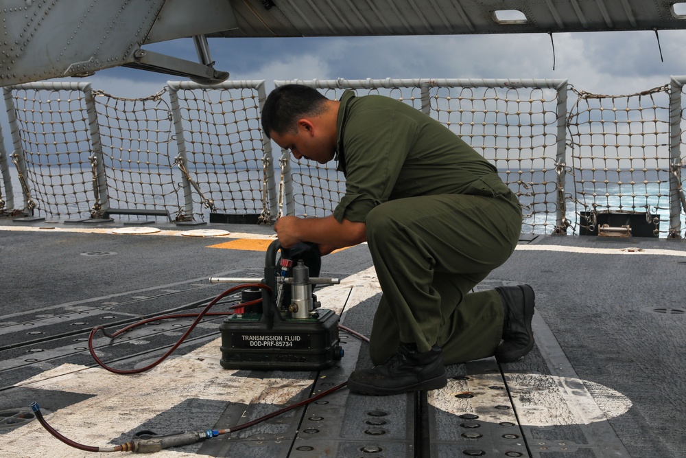 Sailors aboard the USS John Finn conduct routine maintenance on an MH-60R Sea Hawk in the Strait of Malacca
